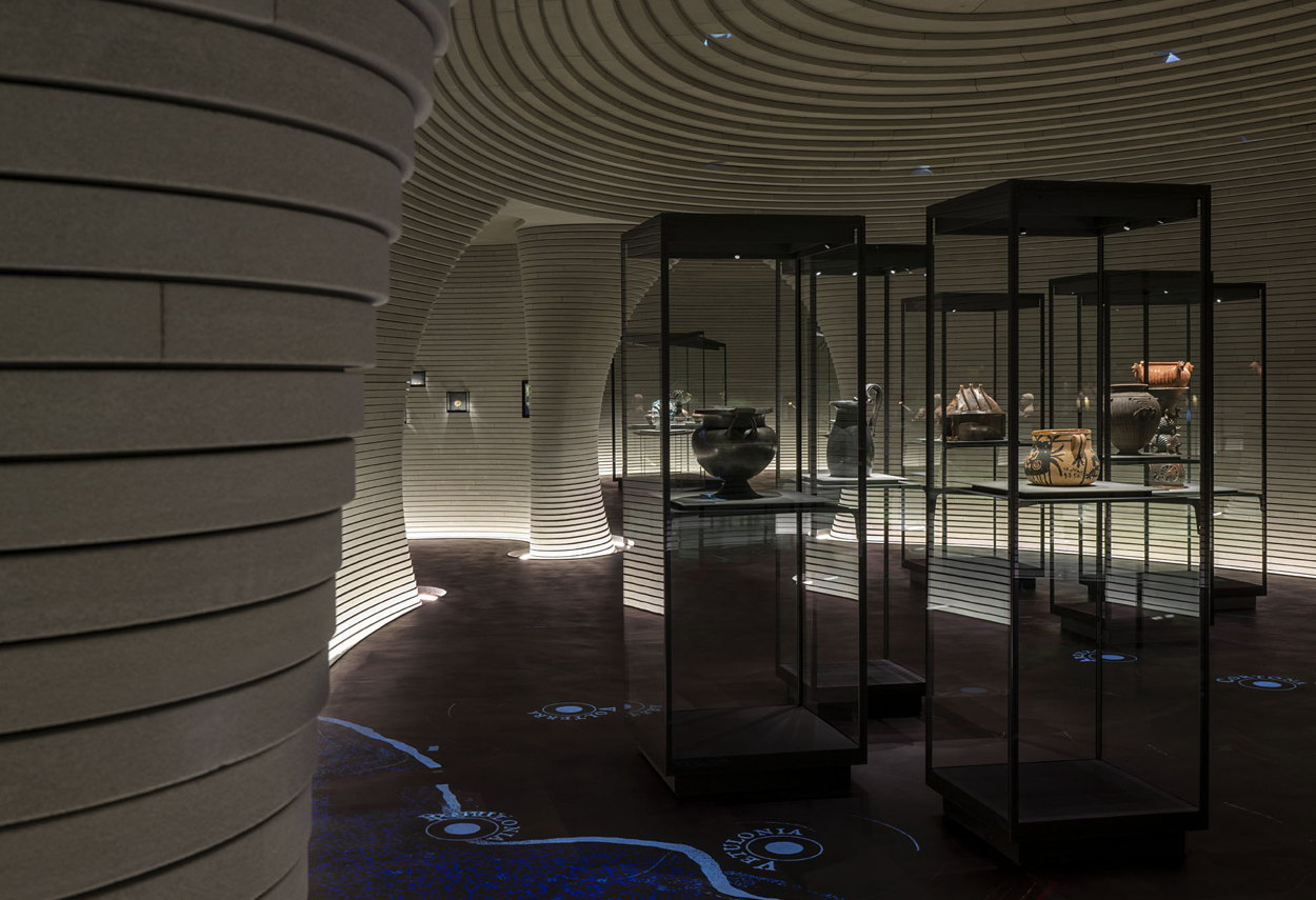 View of the rooms with the projections on the floor and the display cases with the artifacts